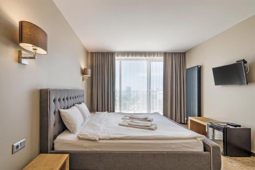 a hotel room with a bed with a large window at Villa Ambra in Tyulenovo