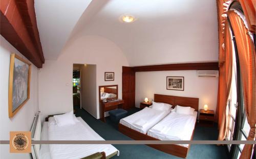 Habitación de hotel con 2 camas y balcón en Hotel Főnix en Pécs