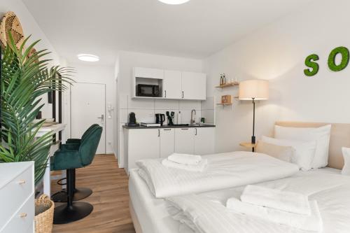 a white room with a bed and a kitchen at SoWi Home - stilvolles Apartment mit Parkplatz - nähe Klinikum und Uni in Kassel