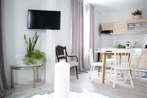 a white living room with a table and chairs at Orsiida deluxe garden house & superior garden apartment Agria in Agria