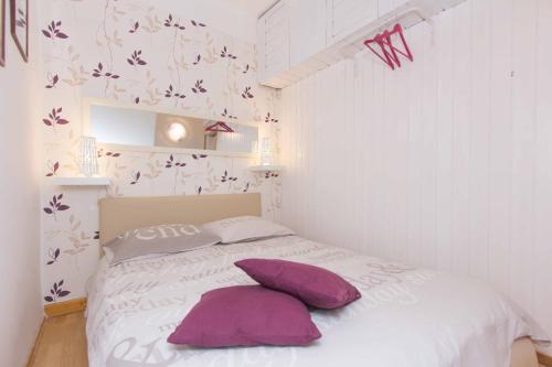 a bedroom with a bed with purple pillows on it at Red Valentino Apartment in Split
