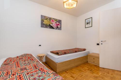 a bedroom with two twin beds and a door at Appartamento Iori in Canazei