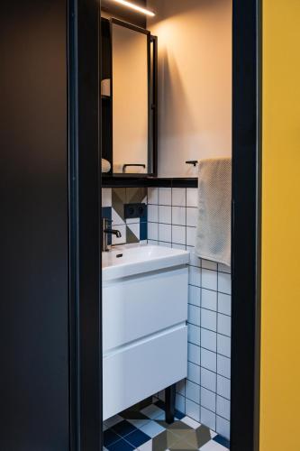 a bathroom with a white sink and a mirror at Apartament Nadolnik Poznań in Poznań