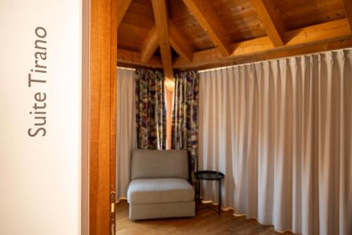 a living room with a chair and curtains at Bernina Express Eco Rooms&Breakfast in Tirano