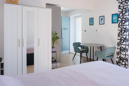 a bedroom with a bed and a table and chairs at Studio apartment above promenade w terrace & parking in Rabac