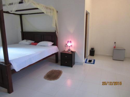 a bedroom with a bed and a lamp on a night stand at Sanderling Silent Beach Cabanas in Tangalle
