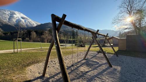 a swing set with a snow covered mountain in the background at Apartments Šlosarjeva Hiša Nature & Tradition in Preddvor