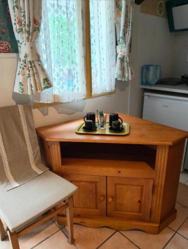 une table en bois et une chaise dans la cuisine dans l'établissement Le Coin des Artistes - Maisonnette, à Giverny