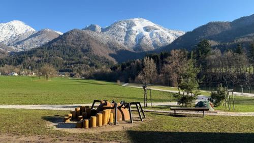 a playground in a field with mountains in the background at Apartments Šlosarjeva Hiša Nature & Tradition in Preddvor