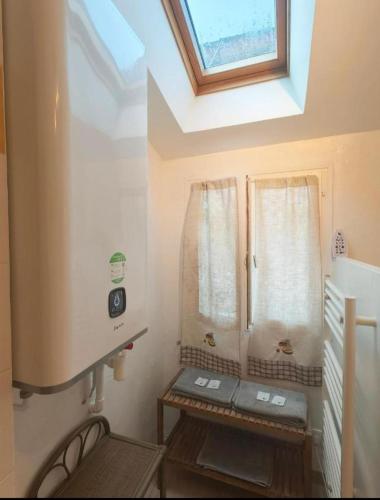 La salle de bains est pourvue d'une douche et d'une fenêtre avec un banc. dans l'établissement Le Coin des Artistes - Maisonnette, à Giverny