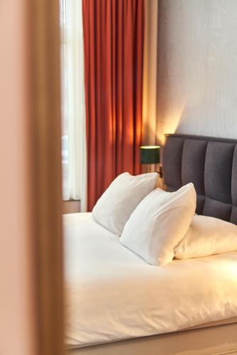 a bedroom with a bed with white sheets and pillows at The Yard hotel Zuidkade in Veghel