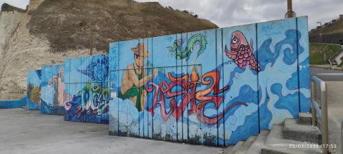 a blue wall with graffiti on it at Maison avec vue sur mer in Saint-Martin-Plage