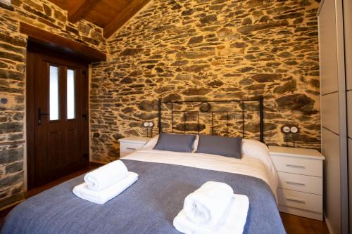 a bedroom with a bed with towels on it at Refuxio de Lamas in Becerreá