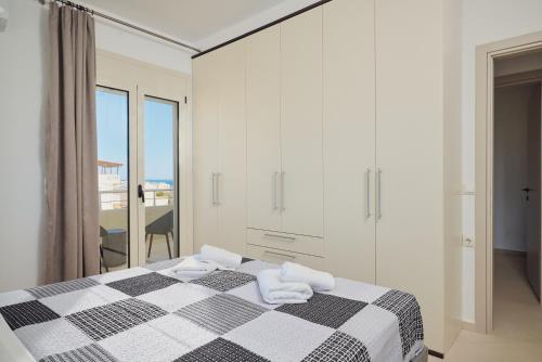 a white bedroom with a black and white bed with towels at Angel's Villa in Kato Gouves
