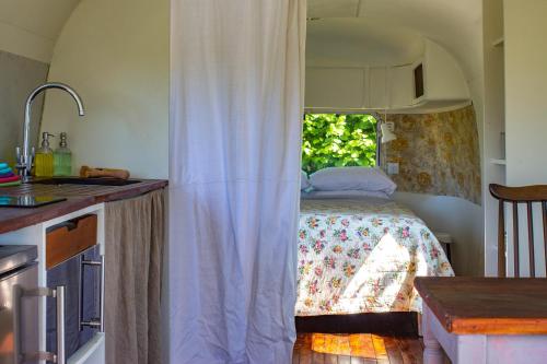 a kitchen with a bed in a room with a window at Luxury Airstream Getaway with Sauna and Hot Tub in Gartness
