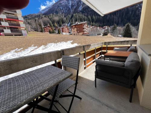a balcony with a table and chairs and a view of a mountain at Sandrina - Studio lumineux et rénové in Leukerbad