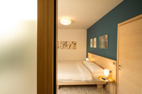 a bedroom with a bed and a blue wall at Bernina Express Eco Rooms&Breakfast in Tirano