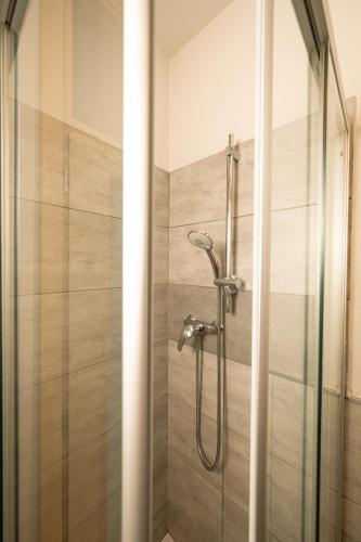 a shower with a glass door in a bathroom at Bernina Express Eco Rooms&Breakfast in Tirano
