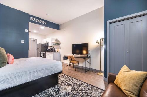 Un dormitorio con una cama y un escritorio y una cocina. en Elegant Downtown Escape with Luxe Vibes, en Macon