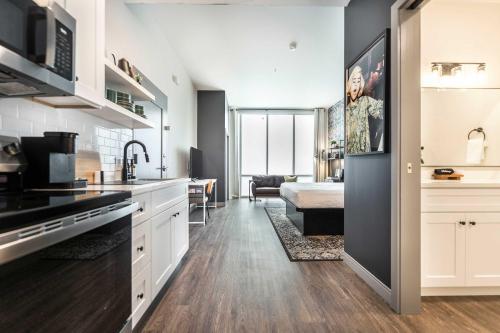 Una cocina con gabinetes blancos y una sala de estar. en Light-Filled Stay with Etta James Flair, en Macon