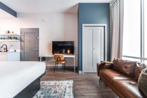 a bedroom with a couch and a table and a desk at Chill Like Gregg Sunlit Southern Vibe in Macon