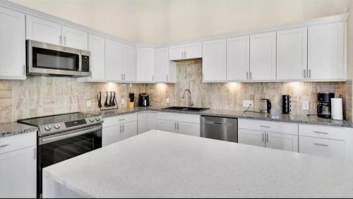 a kitchen with white cabinets and a white counter top at Cheerful Lakeside Retreat-Just Minutes to the lake in Canyon Lake