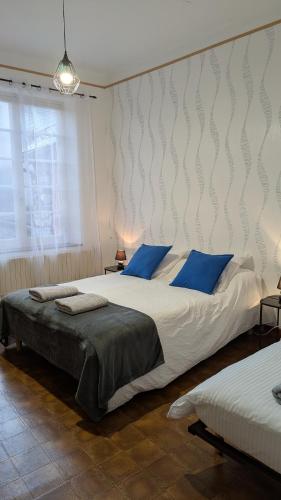 - une chambre avec 2 lits dotés d'oreillers bleus dans l'établissement La maison du sabotier, à Audressein