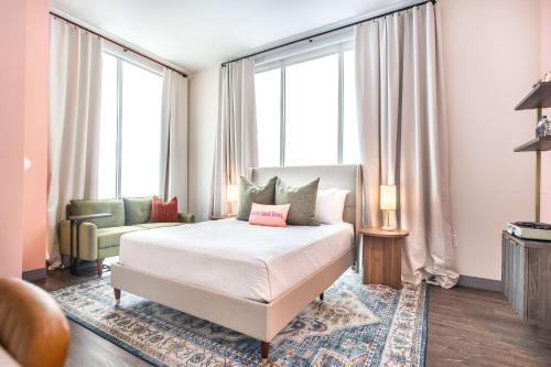 Un dormitorio con una cama y un sofá y ventanas. en Turn Back Time Cher-Inspired Escape, en Macon