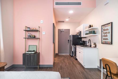 Habitación con paredes rosas y cocina con encimera. en Turn Back Time Cher-Inspired Escape, en Macon