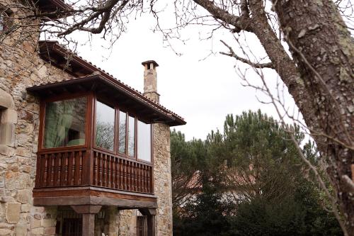 a wooden balcony on the side of a building at Posada La Torre de La Quintana in Liendo