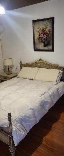 a bedroom with a bed with a painting on the wall at La Fabi in Carmelo
