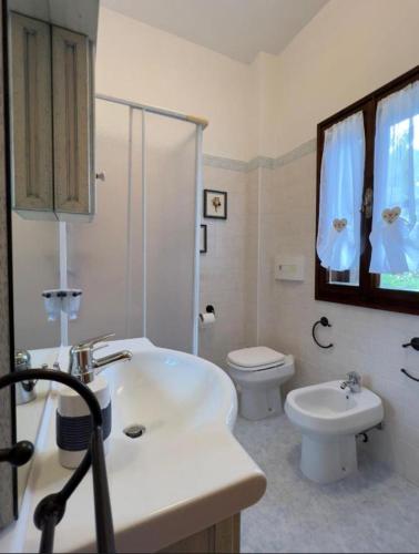 a bathroom with a white sink and a toilet at Casa Betta in Stintino