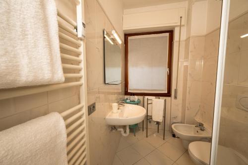 a white bathroom with a sink and a mirror at Bernina Express Eco Rooms&Breakfast in Tirano