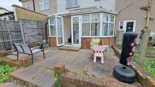 a patio with a chair and a pink table and chairs at Guest house in Dagenham East by Fenia in Dagenham