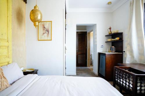 a bedroom with a white bed and a desk at Al Wadi Boutique Hotel in Al Aqālitah