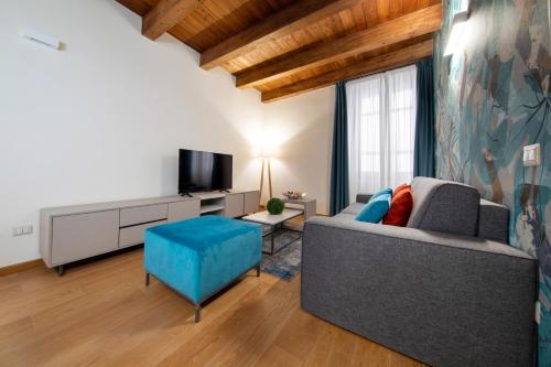 a living room with a couch and a tv at Suite Deluxe in Palazzo Storico - Centro Sassari - Appartamento Calvi in Sassari