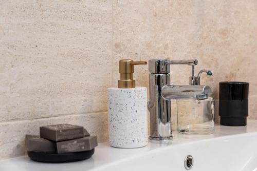 a bathroom sink with a soap dispenser and a faucet at Suite Deluxe in Palazzo Storico - Centro Sassari - Appartamento Calvi in Sassari