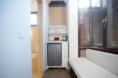 a small kitchen with a bench and a window at Al Wadi Boutique Hotel in Al Aqālitah