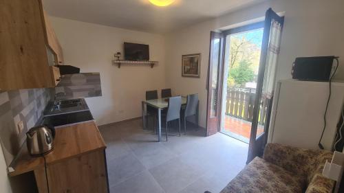 a small kitchen with a table and a refrigerator at Bioledro - Casa Lena in Mezzolago
