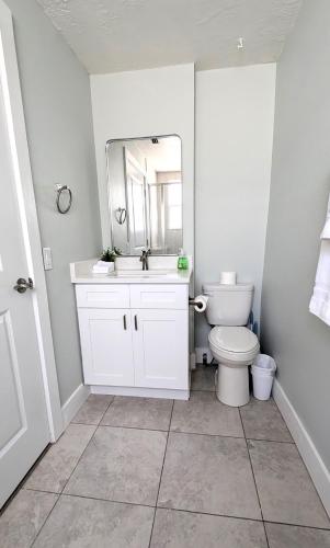 a white bathroom with a toilet and a mirror at Sunny Shores Retreat 6 in Clearwater Beach
