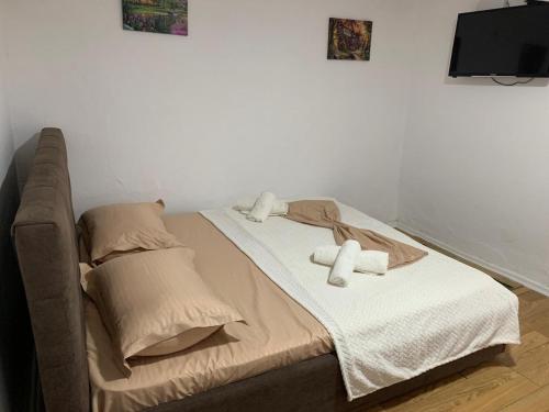 a bed with two towels on it in a room at Guesthouse N&B in Berat