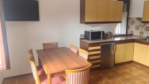 a kitchen with a wooden table and a microwave at Bioledro - Casa Lena in Mezzolago