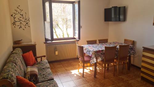 a living room with a table and a couch at Bioledro - Casa Lena in Mezzolago