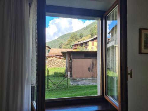 a window with a view of a barn at Bioledro - Casa Lena in Mezzolago