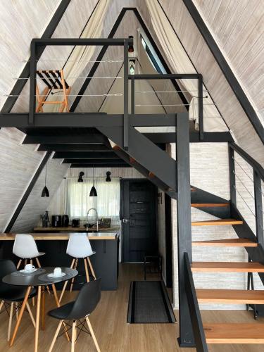 a loft with a staircase and a kitchen with a table and chairs at Chalé Villa Nature in Campos do Jordão