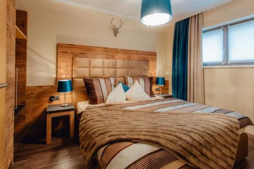 a bedroom with a large bed with a wooden headboard at Residenz Max mit eigenem Garten in Seefeld in Seefeld in Tirol