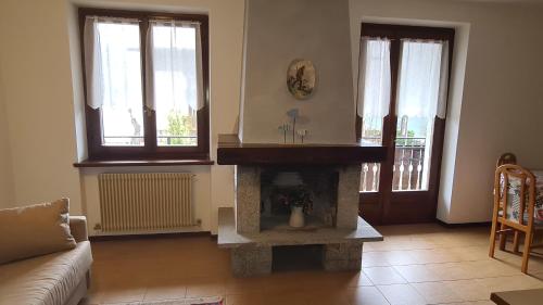 a living room with a fireplace and a couch at Bioledro - Casa Lena in Mezzolago