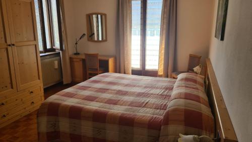 a bedroom with a bed with a checkered blanket at Bioledro - Casa Lena in Mezzolago