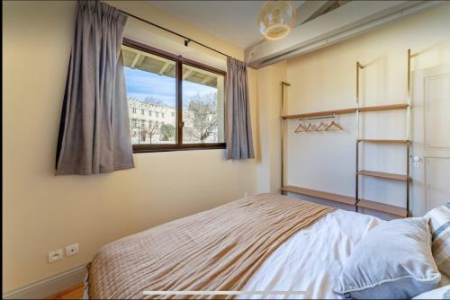 une chambre avec un lit et une fenêtre dans l'établissement Au pied du palais clim parking, à Avignon