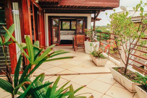 a porch of a house with plants and a bedroom at Pipa Panorama Aparthotel in Pipa